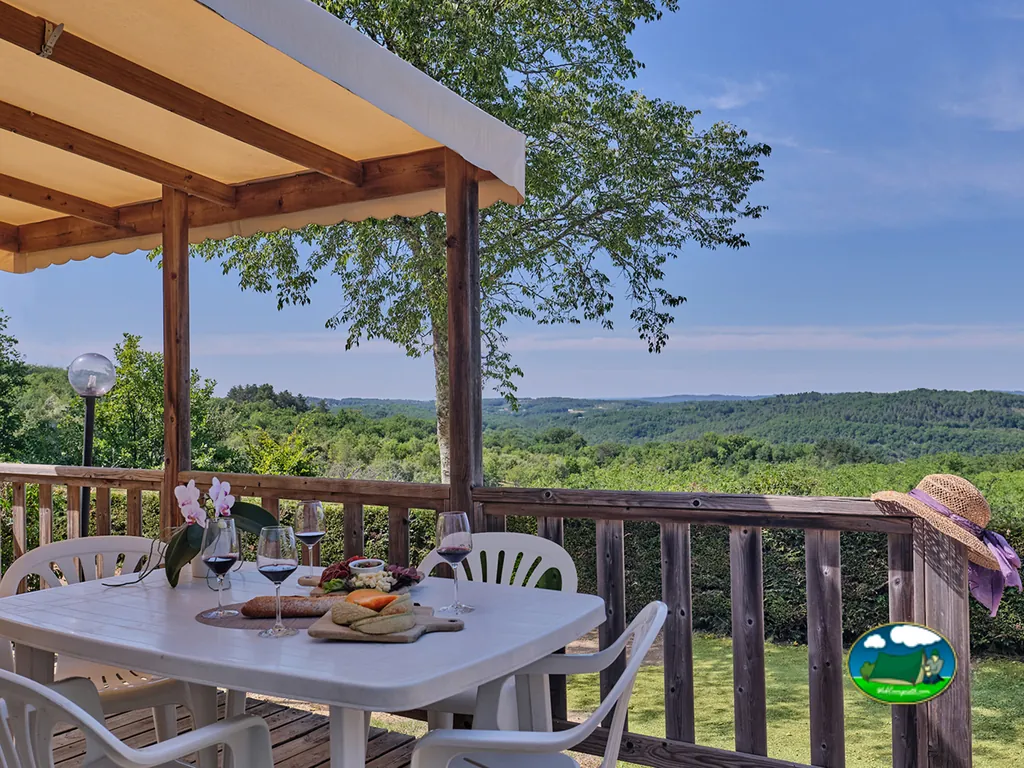 mesa con vino y tabla de quesos en una terraza con vistas a las colinas en Saint-Laurent-la-Vallée
