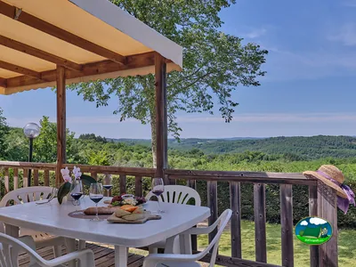 mesa con vino y tabla de quesos en una terraza con vistas a las colinas en Saint-Laurent-la-Vallée