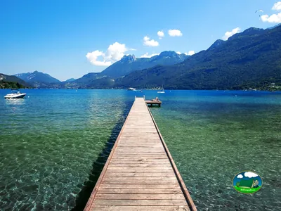 embarcadero de madera sobre el lago con montañas al fondo en el camping Lac Bleu