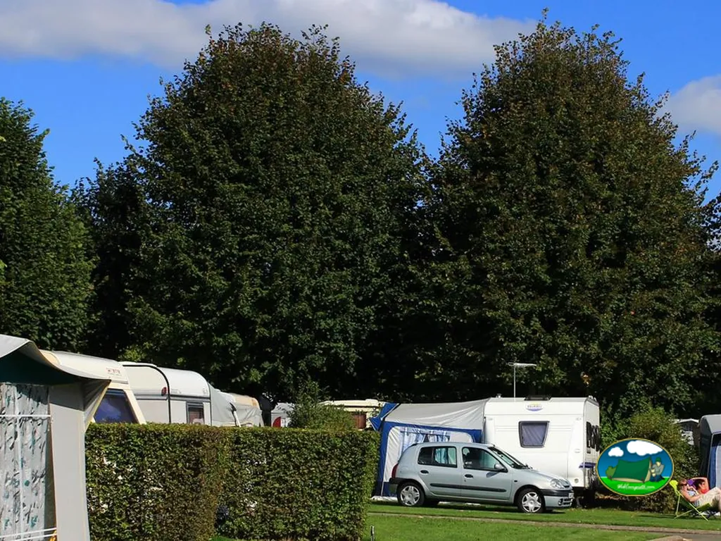 parcelas con caravanas y coche bajo grandes árboles en Bagnoles-de-l'Orne-Normandie