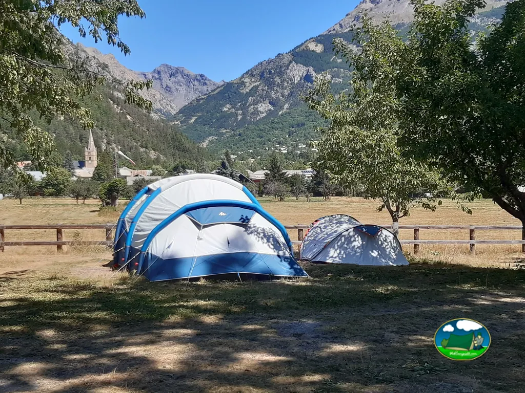 tiendas de campaña en una parcela vallada con vistas al pueblo y las montañas en Vallouise