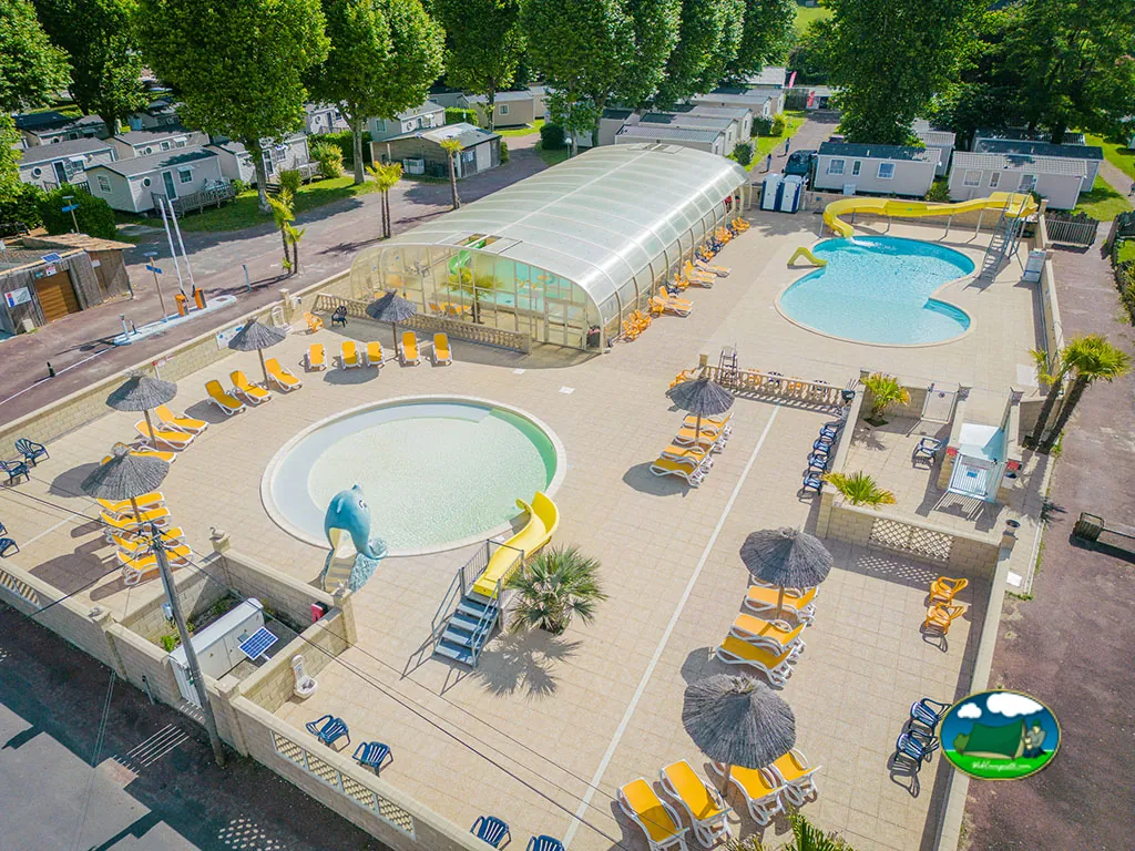 vista aérea del complejo de piscinas con toboganes, piscina cubierta y tumbonas