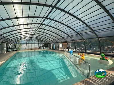 piscina cubierta con toboganes cerrados y flotadores infantiles en el borde