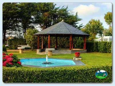 Piscina con jacuzzi y pérgola de madera entre árboles del Camping Vegamar, Castropol (Asturias)