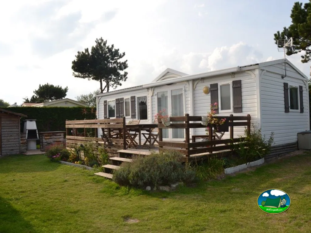 casa móvil blanca con terraza de madera y jardín en Oye-Plage