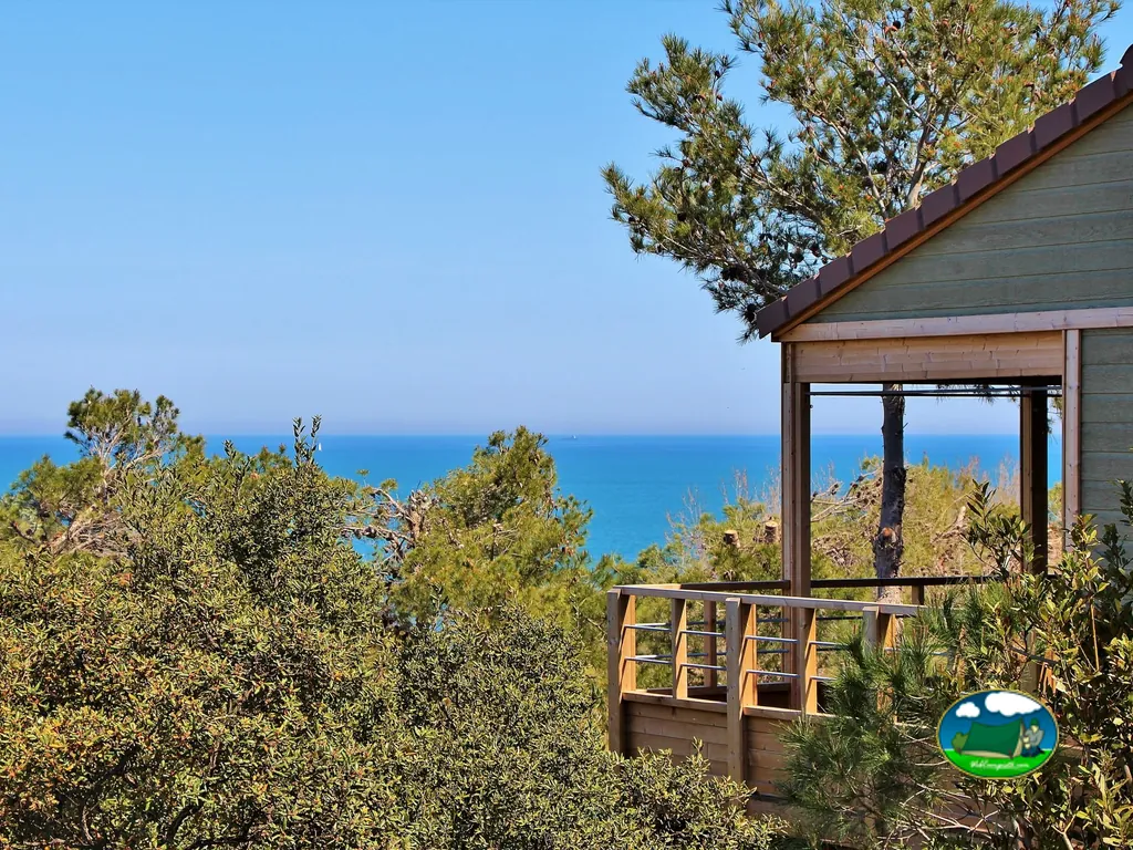 terraza de una cabaña con vistas al mar entre pinos en Collioure