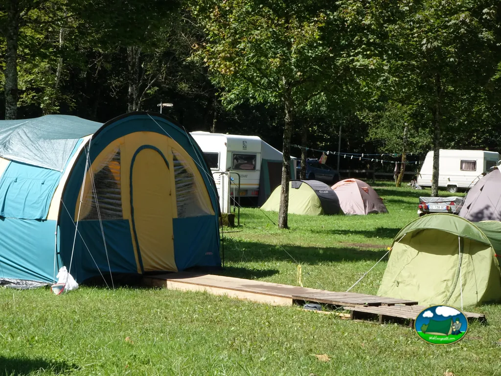 parcelas de acampada con tiendas de campaña y caravanas bajo los árboles en Aiguebelette-le-Lac