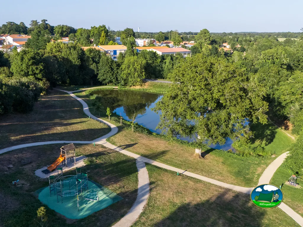 vista aérea de un estanque y una zona infantil con tobogán en el camping cerca de Moutiers-les-Mauxfaits