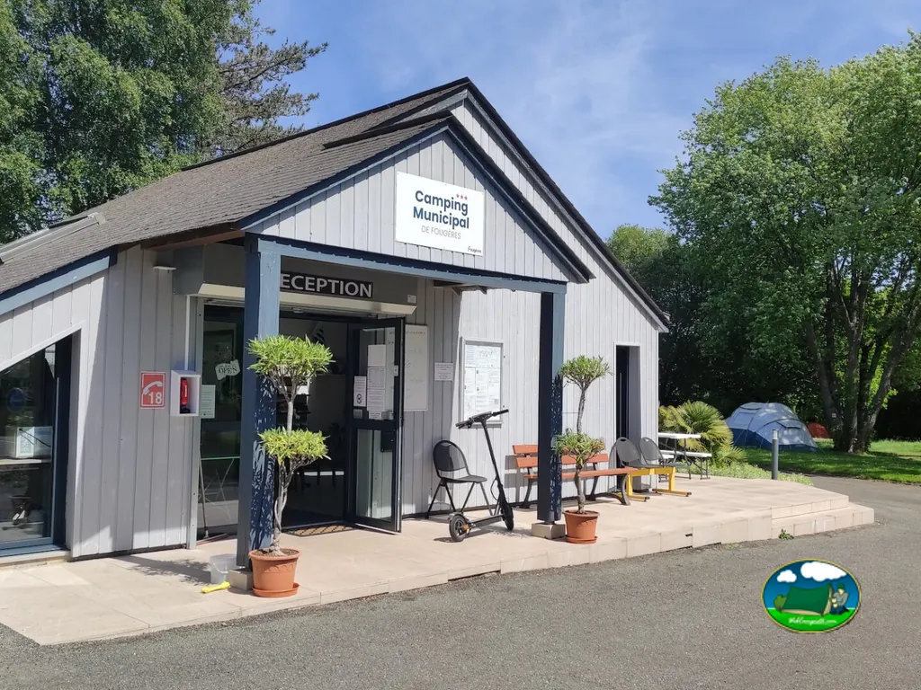 fachada de la recepción con macetas, patinete eléctrico y una tienda de campaña al fondo en Fougères