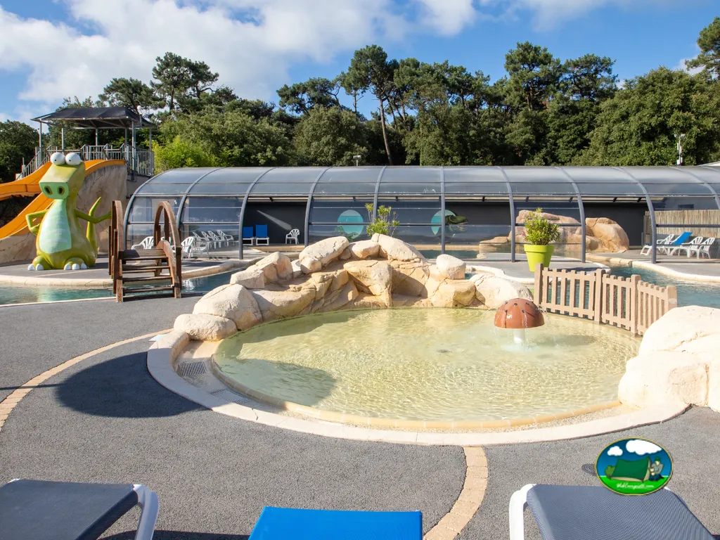 parque acuático infantil con tobogán en forma de dinosaurio y piscina poco profunda