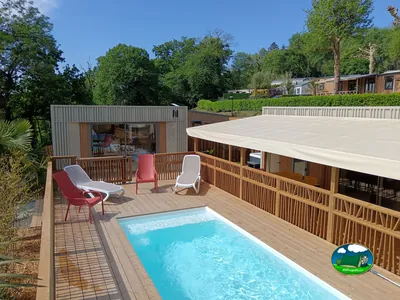 terraza elevada con piscina privada y tumbonas rojas y blancas junto a un bungalow de madera en Taden