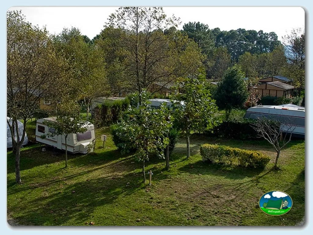 Parcela con mobil-home entre árboles del Camping Playa de Otur, Valdes (Asturias)