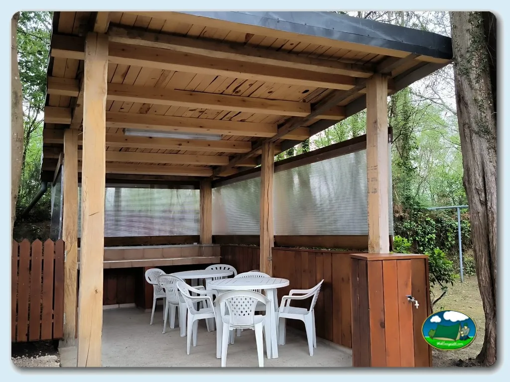 Zona de estar cubierta con mesa y sillas del Camping Playa de Otur, Valdes (Asturias)
