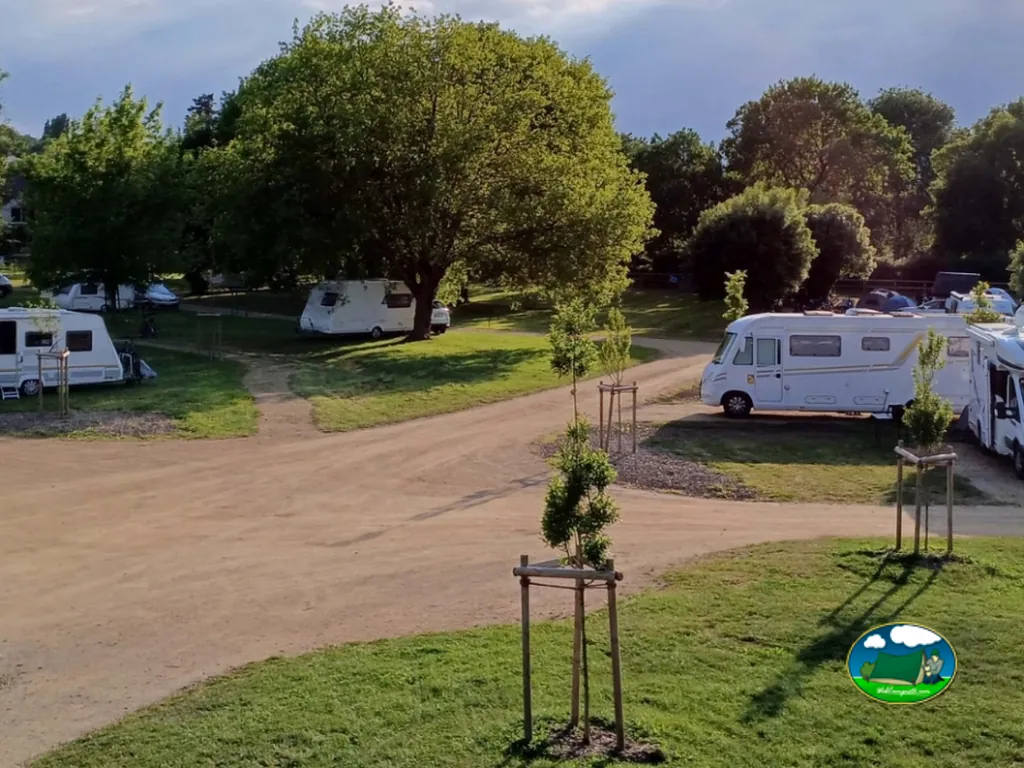 vista aérea de las parcelas del camping con caravanas y autocaravanas entre árboles en Le Lion-d'Angers
