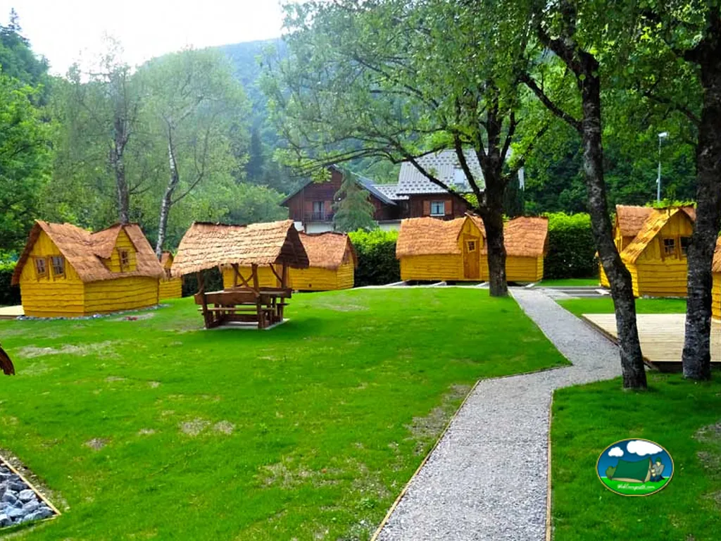 cabañas amarillas de madera con tejado de paja en un prado junto a la montaña en Queige