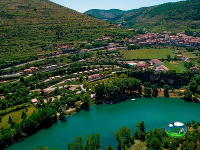 vista aérea del valle con el camping junto a un lago turquesa y el pueblo de Saint-Rome-de-Tarn al fondo