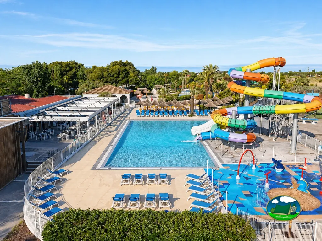 piscina con tobogán multicolor y zona de chapoteo infantil vista desde el aire en el camping de Agde