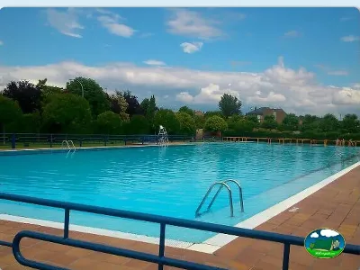 Piscina con vistas al entorno verde del Camping El Antojano, Benavides de Orbigo (León)