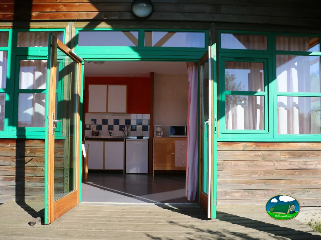 puertas acristaladas abiertas hacia la cocina de un alojamiento del camping