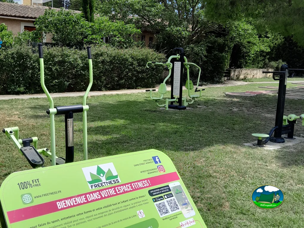 zona de aparatos de fitness al aire libre del camping, con un cartel informativo en primer plano