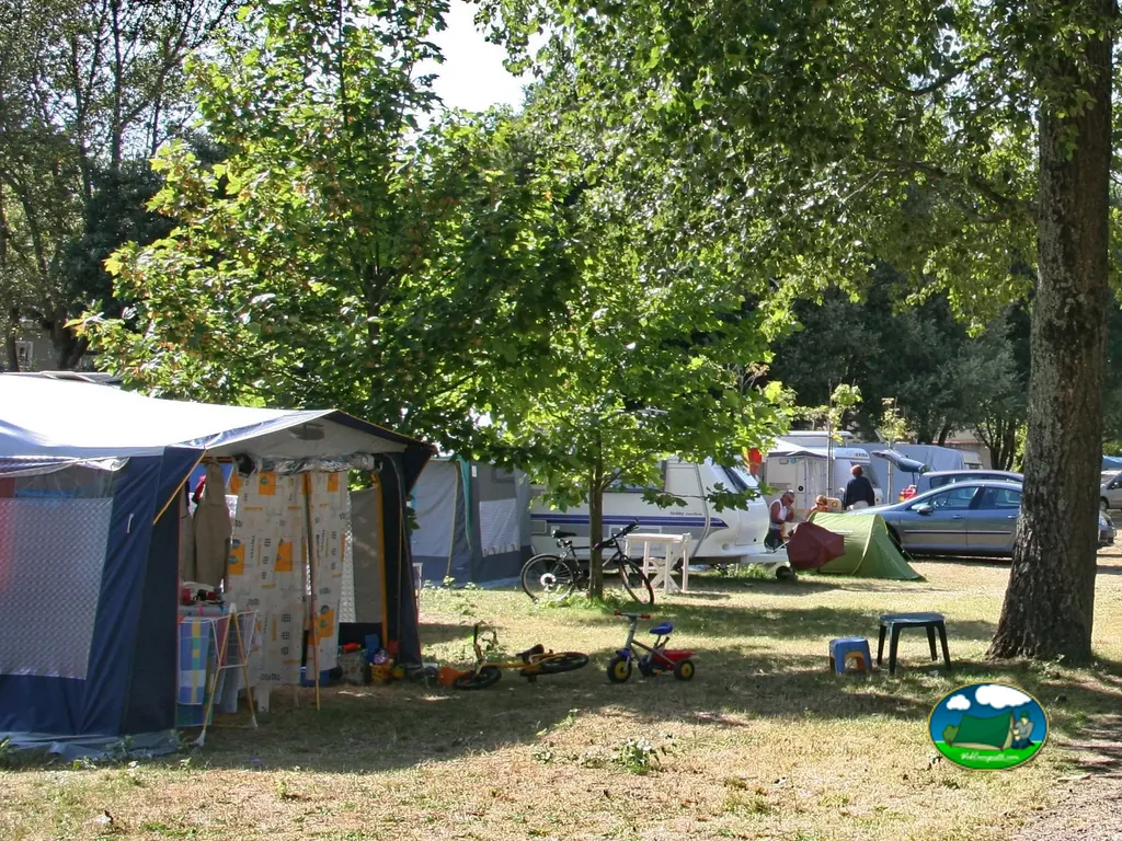 parcelas arboladas con tiendas, autocaravana y bicicletas de los campistas en Pornichet