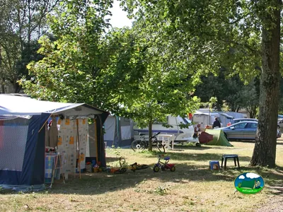 parcelas arboladas con tiendas, autocaravana y bicicletas de los campistas en Pornichet