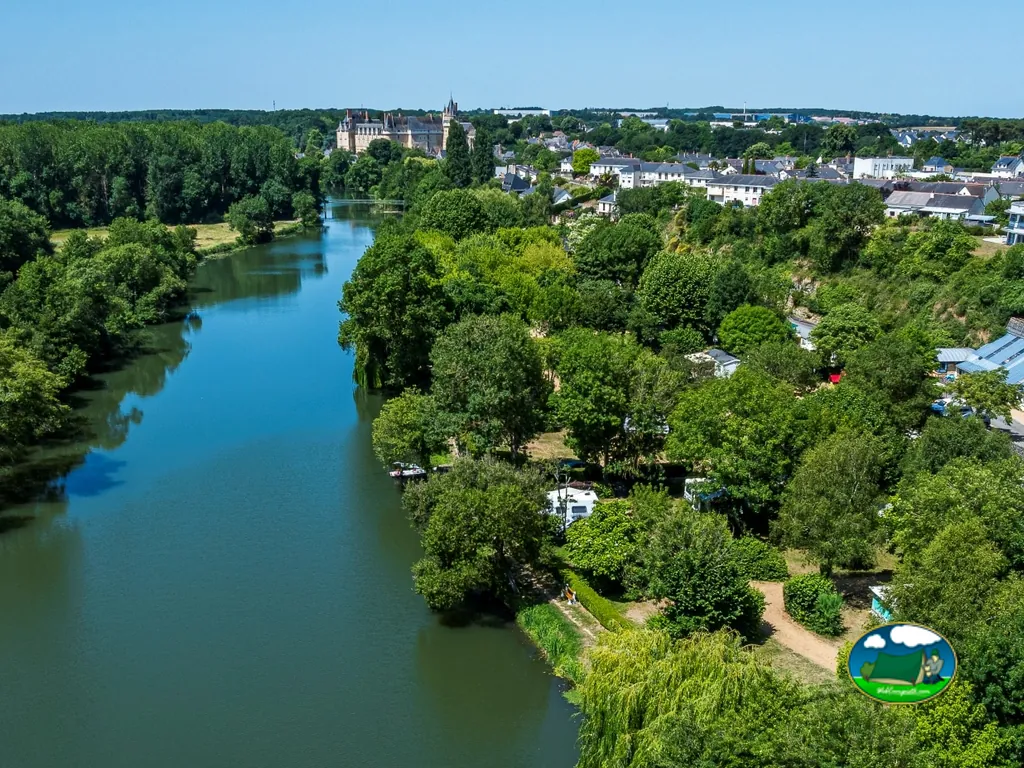 vista aérea del río junto al pueblo con parcelas de caravanas entre los árboles en Durtal