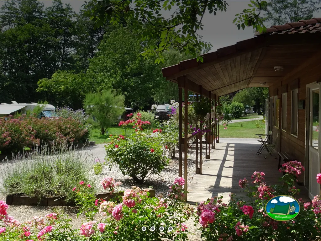 jardín con rosas y lavanda junto al porche de una cabaña de madera