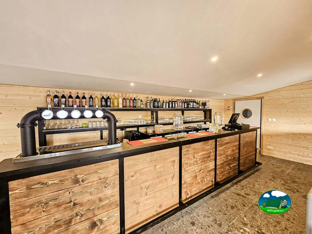barra de bar de madera con grifos de cerveza y botellas en las estanterías