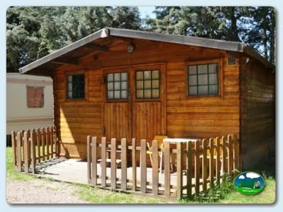 Cabaña de madera con terraza y valla del Camping La Capea, Aldeaseca de Armuña (Salamanca)