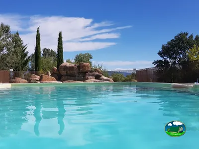 piscina con cascada de rocas ornamentales y cipreses junto a vistas a las colinas en Le Puy-Sainte-Réparade
