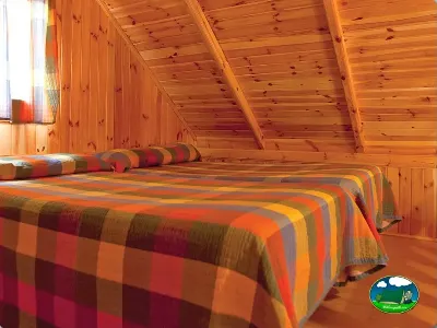 Cabaña interior con camas y vigas de madera del Camping Regio, Sta Marta de Tormes (Salamanca)