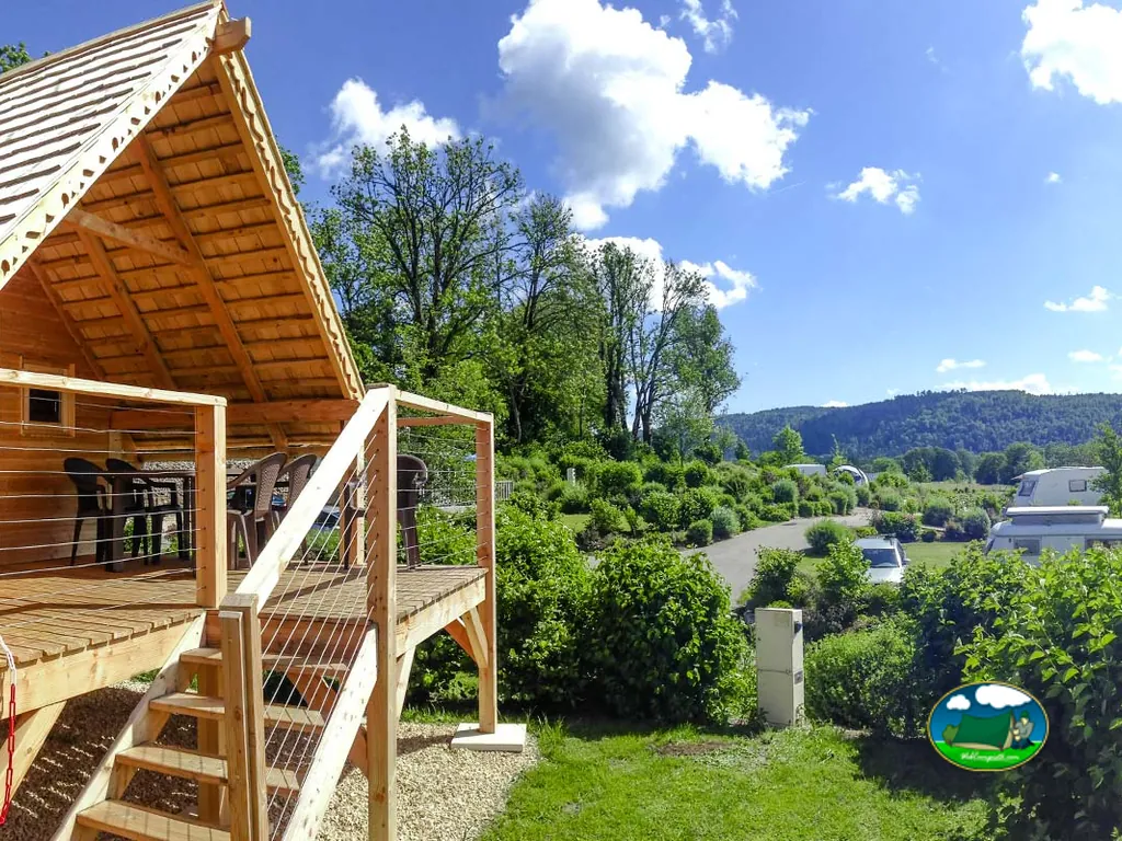 terraza de madera elevada con vistas al camino del camping y las caravanas entre montañas en Plateau d'Hauteville