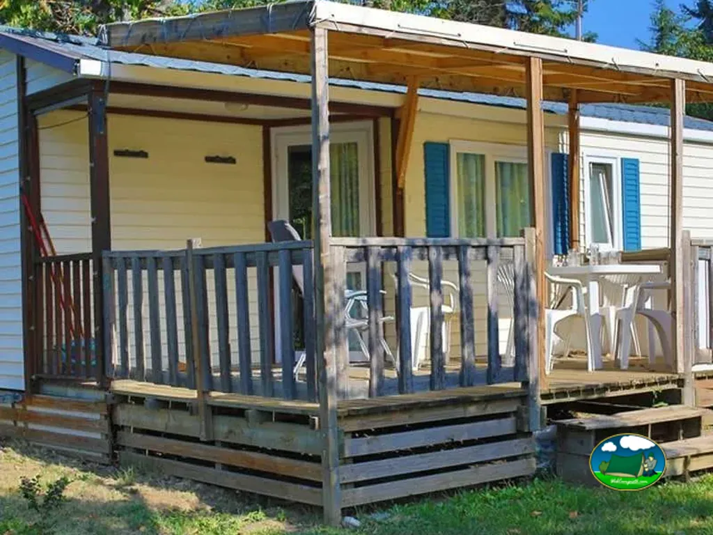 mobil-home con porche cubierto y mesa exterior en el camping de Montéglin