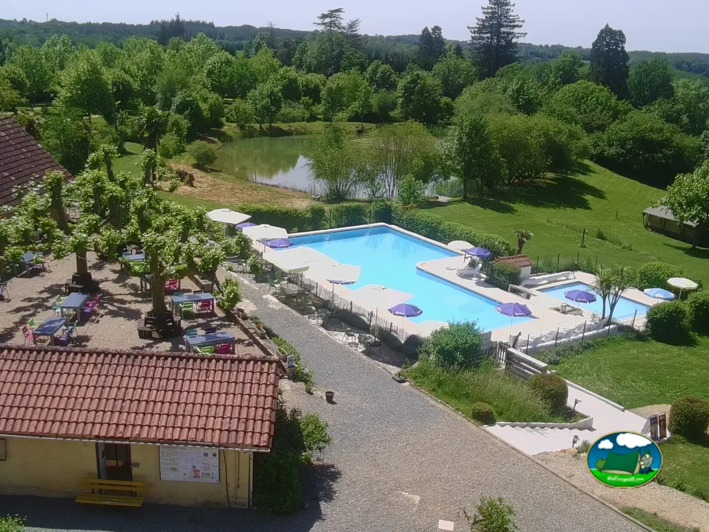 vista aérea de una casa con piscina, estanque y jardines arbolados en Douville
