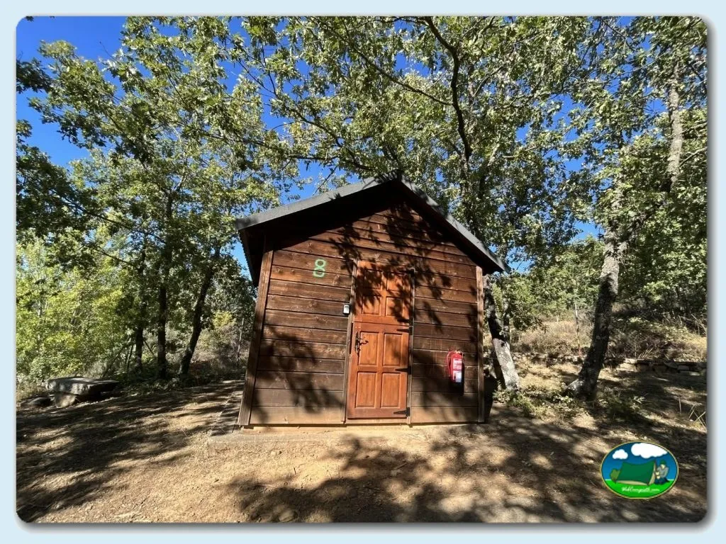 Cabaña de madera entre árboles del Camping La Devesa Aventura, Bembibre (León)