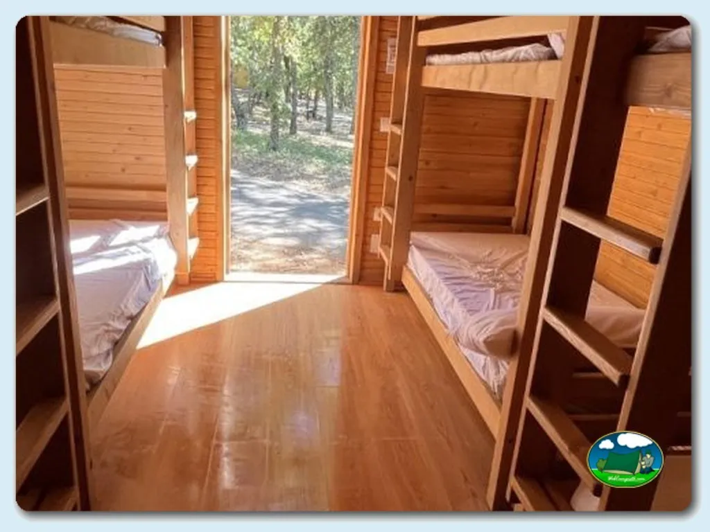 Cabaña interior con literas y vistas al bosque del Camping La Devesa Aventura, Bembibre (León)