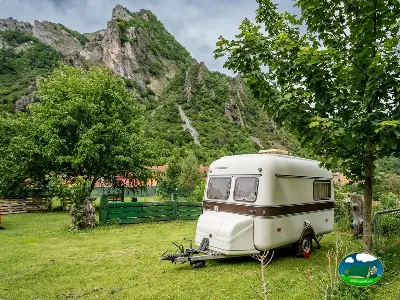 Caravana vintage en parcela con vistas a la montaña del Camping La Pomarada de Somiedo, Pola de Somiedo (Asturias)