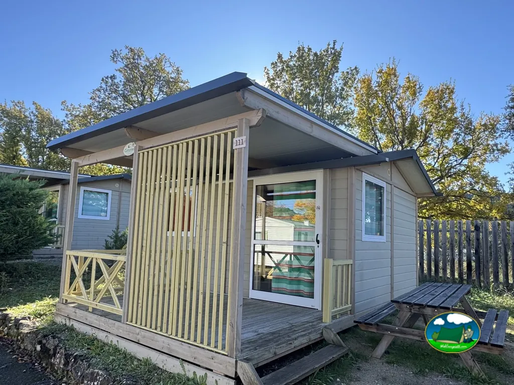 bungaló numerado con porche de listones de madera y merendero en el camping Le Verseau