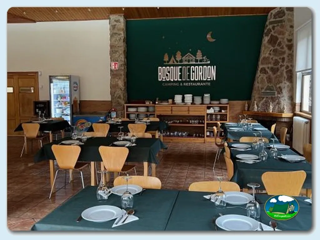 Restaurante con mesas servidas y decoración moderna del Camping Bosque de Gordon, La Pola de Gordon (León)