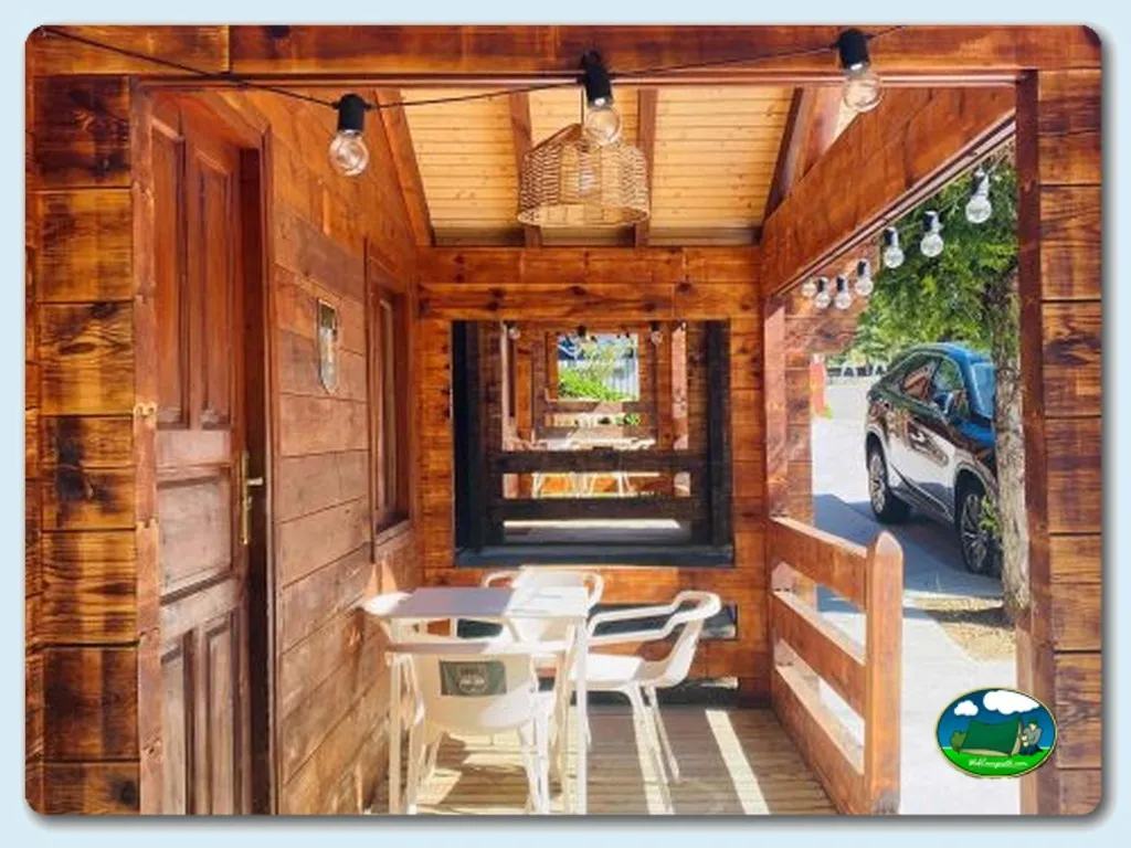 Glamping cabaña de madera con terraza y mobiliario del Camping Bosque de Gordon, La Pola de Gordon (León)