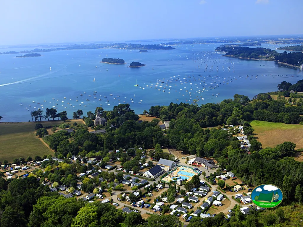 vista aérea del camping de Penboch con piscina y parcelas junto al golfo de Morbihan salpicado de veleros