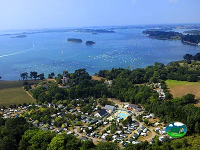 vista aérea del camping de Penboch con piscina y parcelas junto al golfo de Morbihan salpicado de veleros