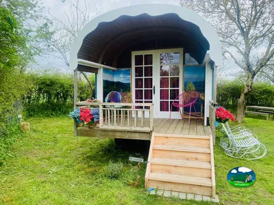 carromato de madera con terraza decorada, flores y sillas en Lapeyrouse