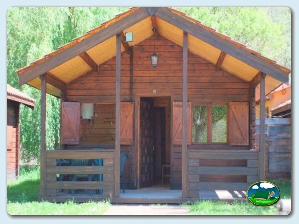 Cabaña de madera con porche y vistas al bosque del Camping Las Hoces, Vegacervera (León)