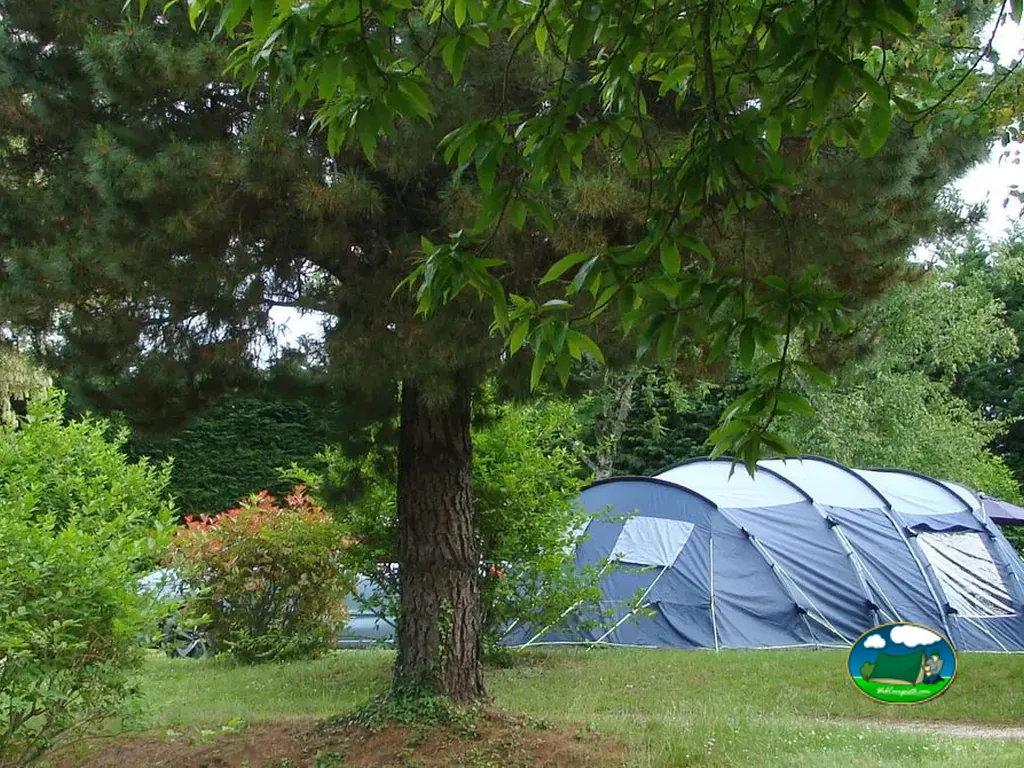 parcela de acampada con una gran tienda de campaña familiar tras un árbol en Le Vigan