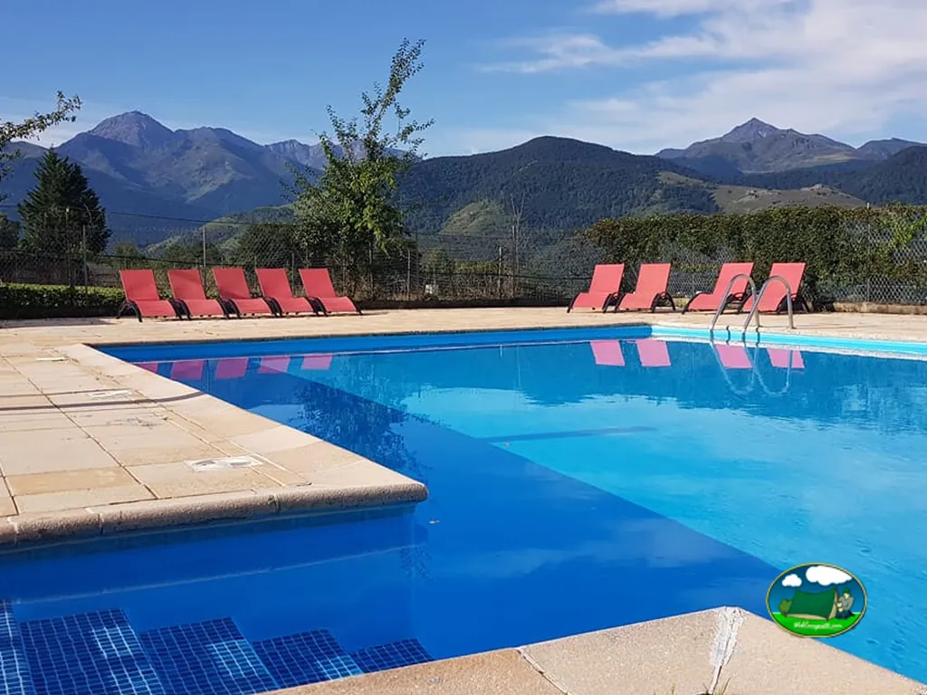 piscina con tumbonas rojas y vistas a los Pirineos en Bagnères-de-Bigorre