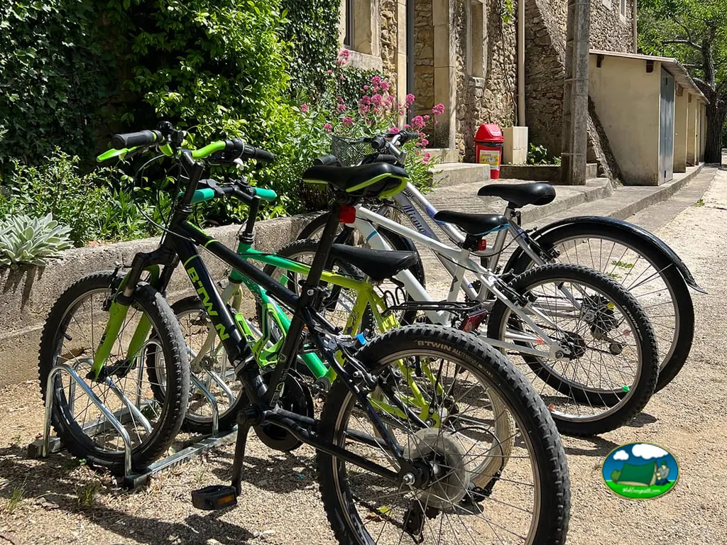 bicicletas aparcadas junto a un edificio de piedra del camping con flores en la fachada
