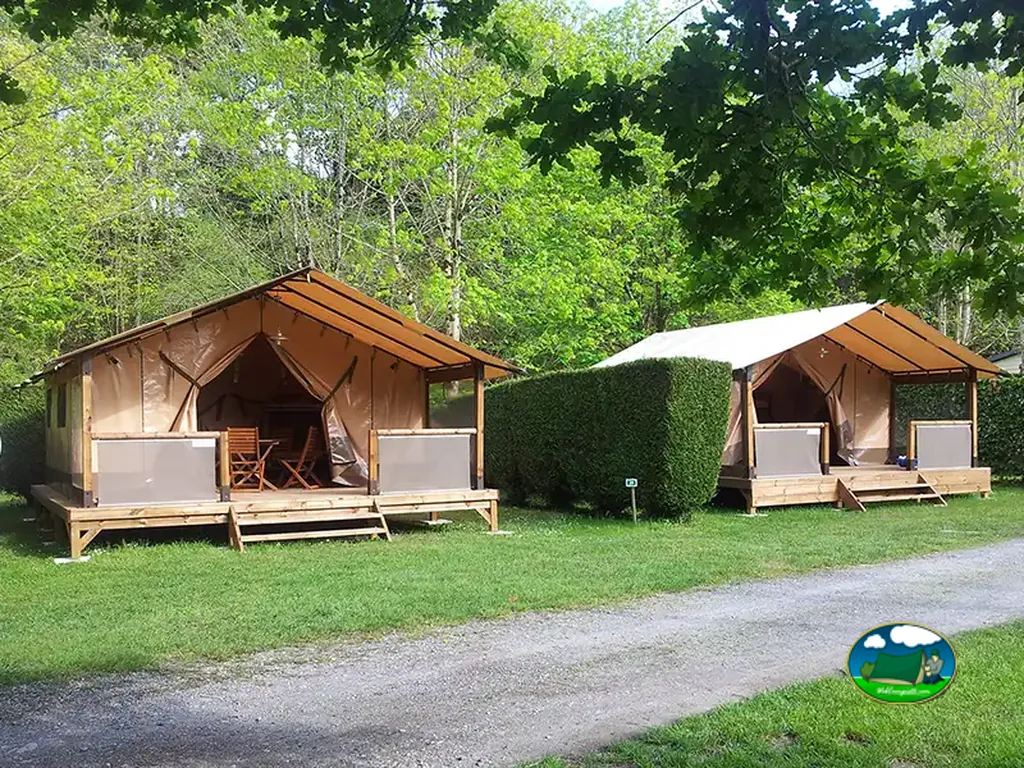 dos tiendas glamping con terraza de madera separadas por un seto en Aren