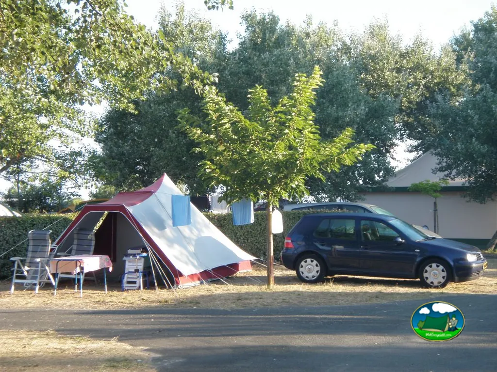 parcela con tienda de campaña, mesa y coche aparcado bajo los árboles en Gujan-Mestras